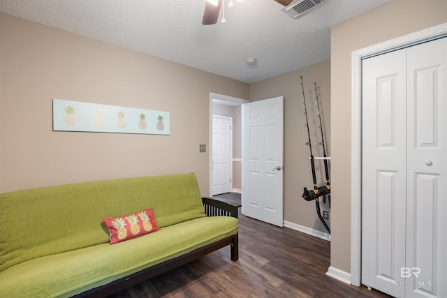sitting room with a textured ceiling, visible vents, dark wood-style flooring, a ceiling fan, and baseboards