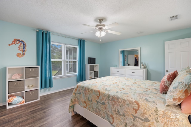 bedroom with a ceiling fan, a textured ceiling, visible vents, dark wood-style flooring, and baseboards