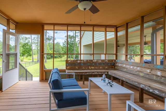 sunroom / solarium featuring a ceiling fan and plenty of natural light
