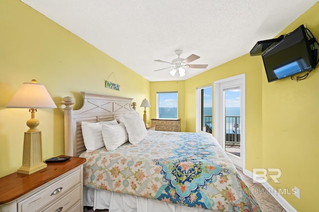 bedroom with access to exterior, a textured ceiling, and ceiling fan