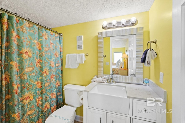 bathroom featuring vanity, a textured ceiling, and toilet