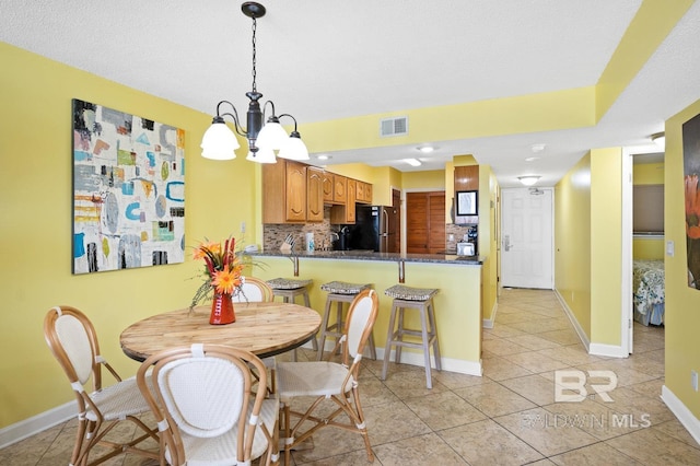 dining space featuring a notable chandelier and light tile patterned flooring