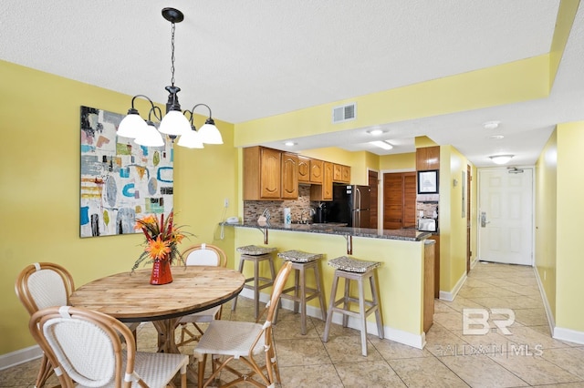 tiled dining space featuring a notable chandelier