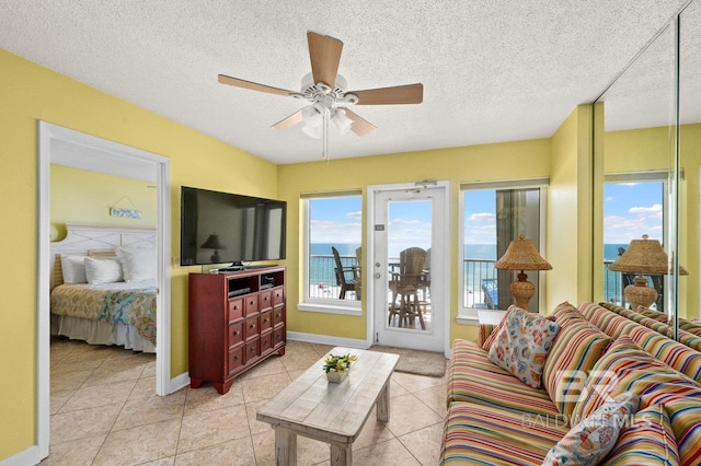 tiled living room with ceiling fan and a textured ceiling