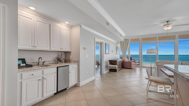 kitchen with light stone countertops, ceiling fan, stainless steel dishwasher, sink, and white cabinetry