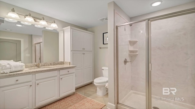 bathroom featuring a shower with shower door, tile flooring, vanity, and toilet