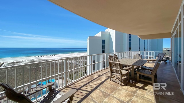 balcony featuring a view of the beach and a water view