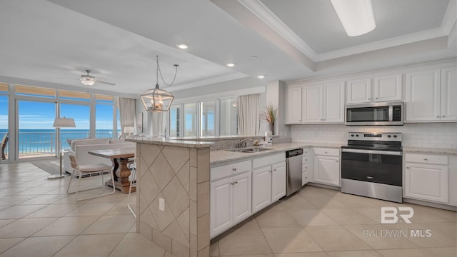 kitchen with crown molding, kitchen peninsula, stainless steel appliances, light tile flooring, and sink