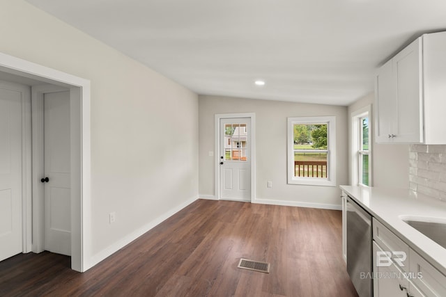 kitchen featuring white cabinets, visible vents, vaulted ceiling, and dishwasher