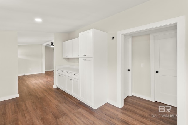 hall with dark wood-style floors, recessed lighting, and baseboards