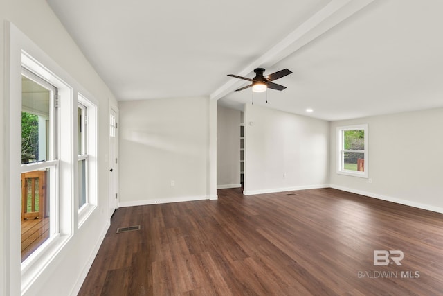 empty room with a ceiling fan, lofted ceiling with beams, dark wood finished floors, baseboards, and visible vents