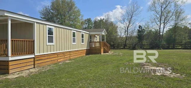 view of home's exterior featuring fence, board and batten siding, and a yard
