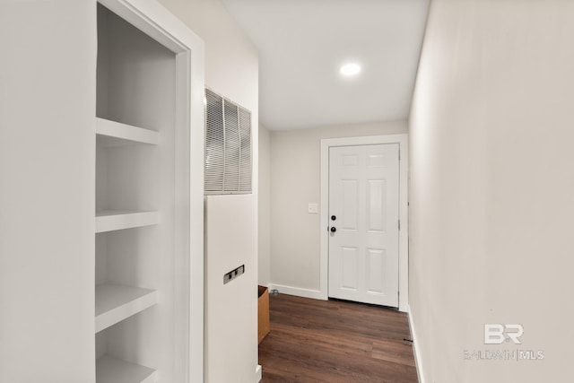 hall featuring recessed lighting, dark wood-style flooring, a heating unit, baseboards, and built in shelves