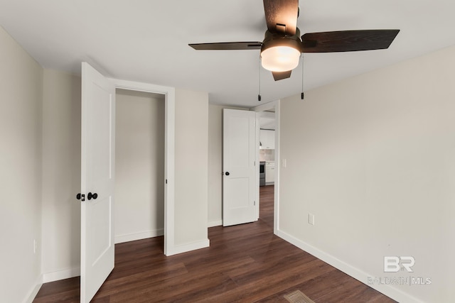 unfurnished bedroom featuring a ceiling fan, dark wood-type flooring, baseboards, and visible vents