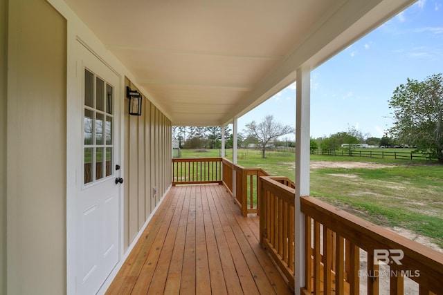 wooden deck featuring a rural view and a yard