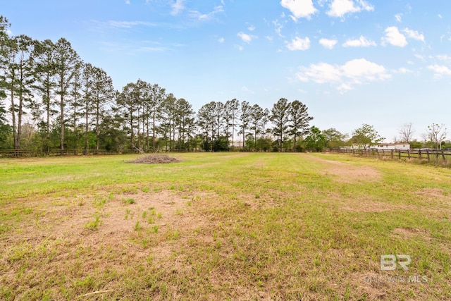 view of yard featuring fence and a rural view