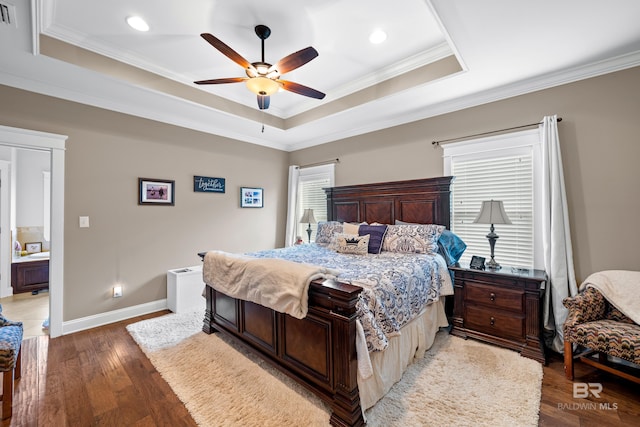 bedroom featuring a tray ceiling, ceiling fan, ornamental molding, and light wood-type flooring