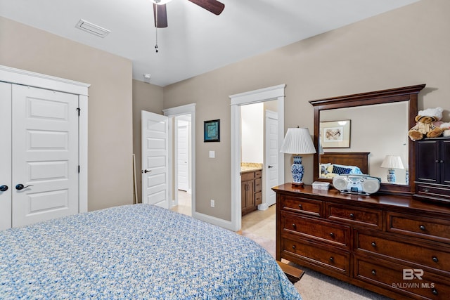 bedroom featuring ceiling fan, light colored carpet, and connected bathroom