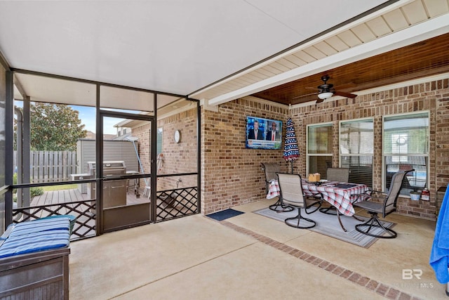 unfurnished sunroom with ceiling fan