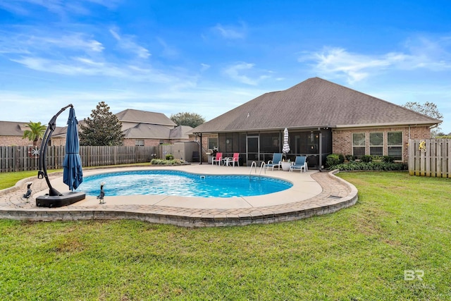 view of swimming pool with a lawn and a sunroom