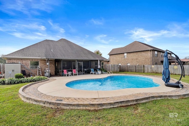 view of pool featuring a sunroom, a patio area, and a lawn