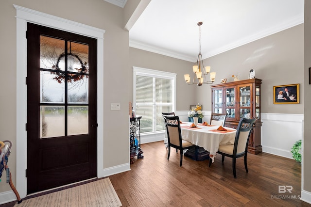 dining area featuring dark hardwood / wood-style floors, ornamental molding, and a chandelier