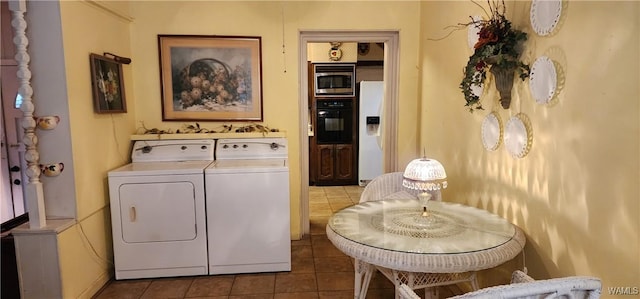 washroom with washer and clothes dryer and dark tile patterned floors