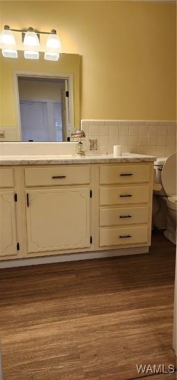 bathroom featuring vanity, wood-type flooring, and toilet