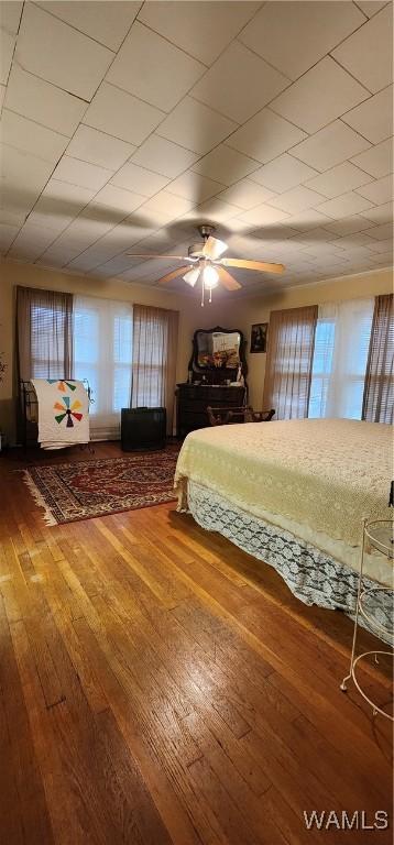 unfurnished bedroom with multiple windows, hardwood / wood-style floors, and ceiling fan