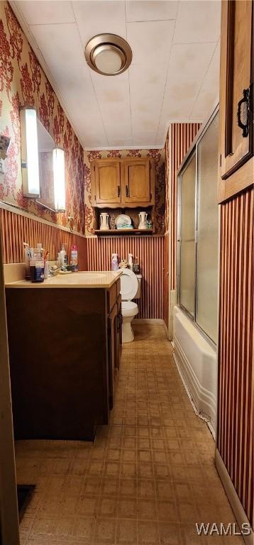 full bathroom with vanity, bath / shower combo with glass door, and toilet