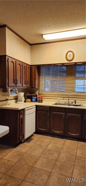 kitchen featuring dark brown cabinetry, dishwasher, light tile patterned flooring, and sink