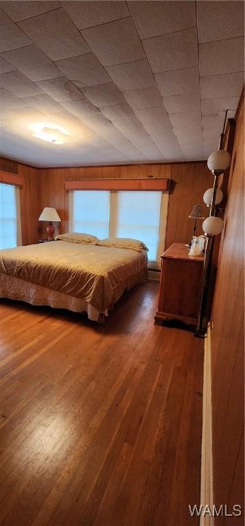 unfurnished bedroom featuring wooden walls and dark hardwood / wood-style flooring