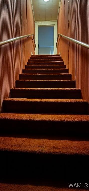 staircase with wood walls