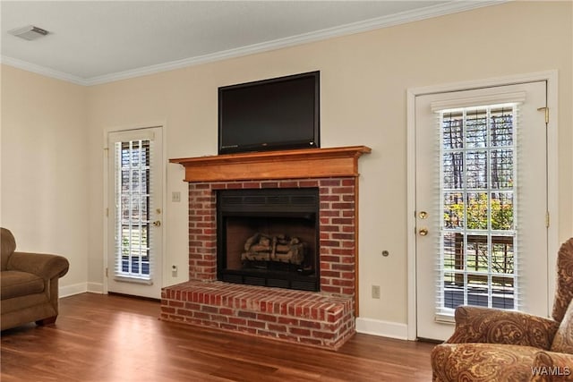 17174 Finnell Rd, Northport, AL 35475 - living room featuring wood finished floors, baseboards, visible vents, a fireplace, and ornamental molding