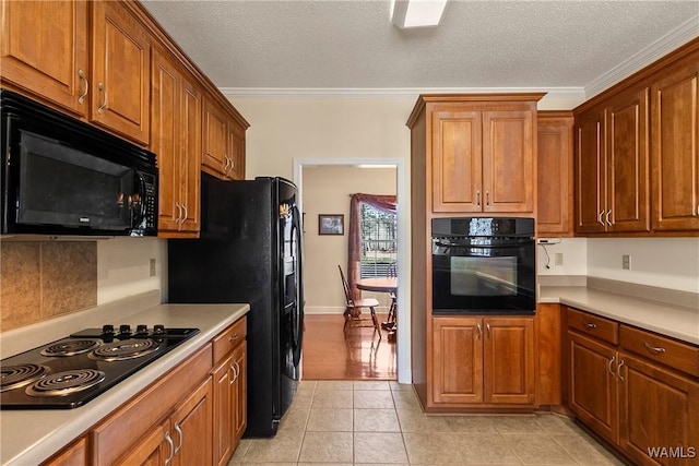 17174 Finnell Rd, Northport, AL 35475 - kitchen with light tile patterned floors, ornamental molding, black appliances, light countertops, and brown cabinets