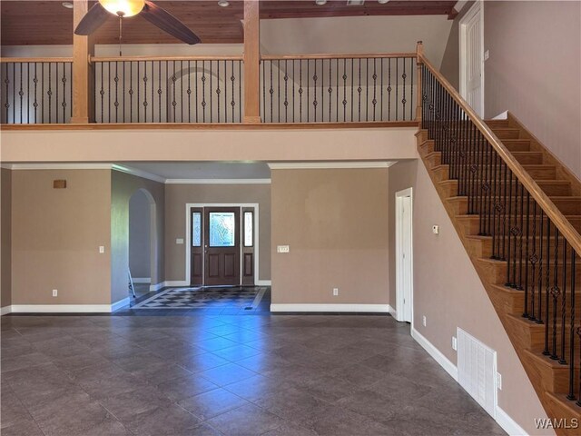 10617 Austin Loop, Vance, AL 35490 - unfurnished living room featuring a high ceiling, a ceiling fan, arched walkways, stairs, and crown molding
