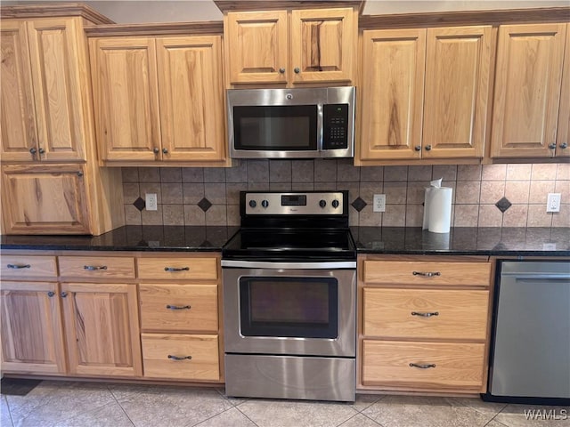 10617 Austin Loop, Vance, AL 35490 - kitchen featuring appliances with stainless steel finishes, light tile patterned floors, dark stone counters, and decorative backsplash