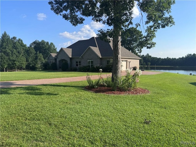 10617 Austin Loop, Vance, AL 35490 - view of front facade featuring driveway, a front yard, a water view, and a garage