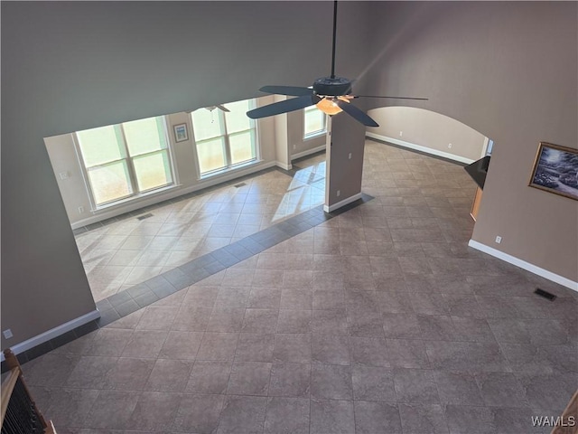 10617 Austin Loop, Vance, AL 35490 - unfurnished living room with ceiling fan, arched walkways, a high ceiling, and dark tile patterned floors