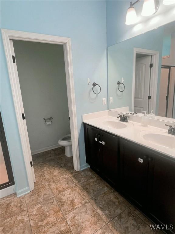 11507 Belle Meade Ave, Northport, AL 35475 - full bath with double vanity, toilet, baseboards, and tile patterned flooring