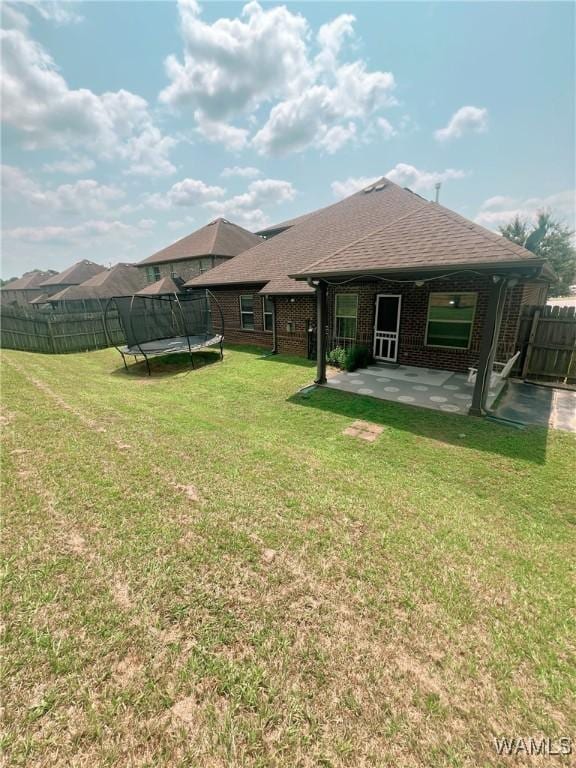 11507 Belle Meade Ave, Northport, AL 35475 - back of house with a trampoline, a patio, brick siding, and a shingled roof