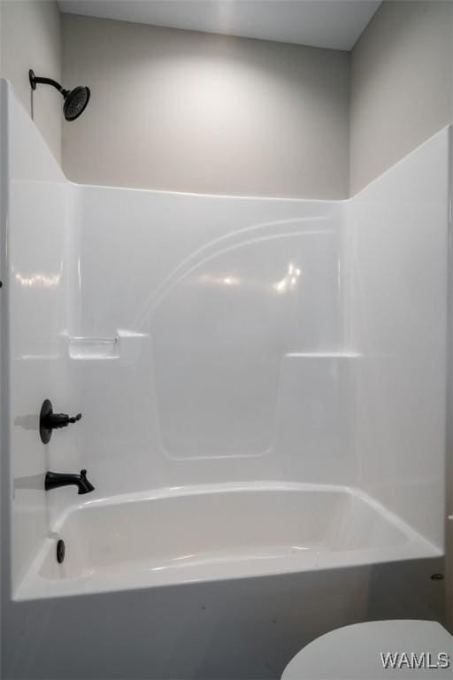 bathroom with shower / bathing tub combination and toilet