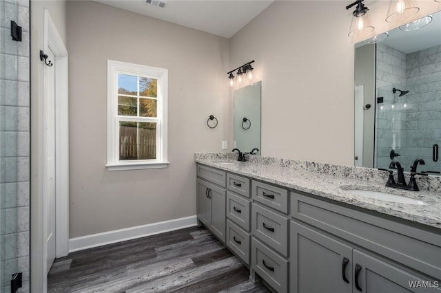 bathroom with vanity, an enclosed shower, and hardwood / wood-style flooring