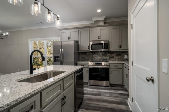 kitchen with dark hardwood / wood-style flooring, ornamental molding, stainless steel appliances, sink, and hanging light fixtures