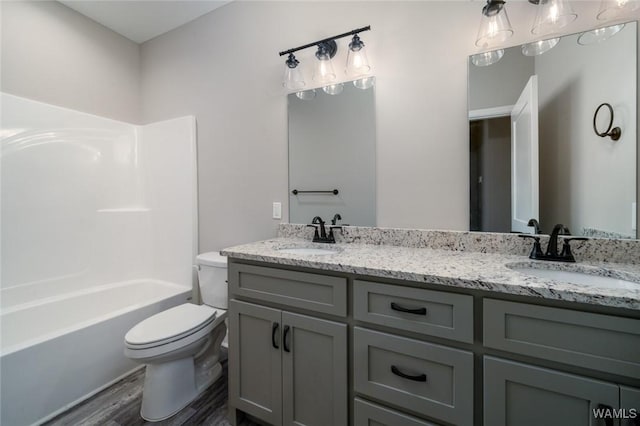 full bathroom with vanity, wood-type flooring, shower / bathtub combination, and toilet