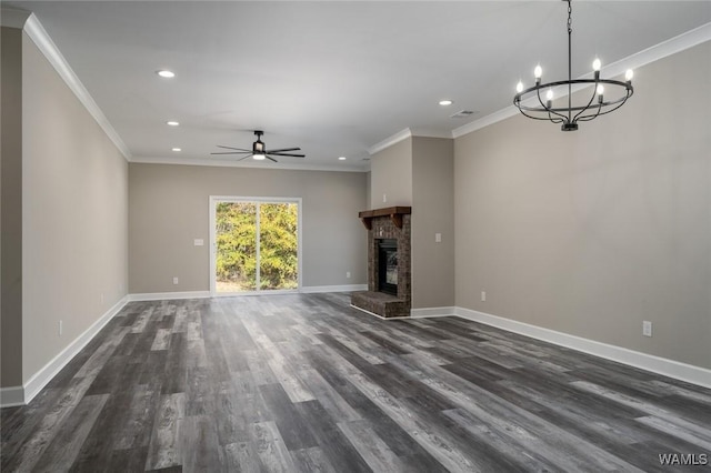unfurnished living room featuring crown molding, a fireplace, dark wood-type flooring, and ceiling fan with notable chandelier