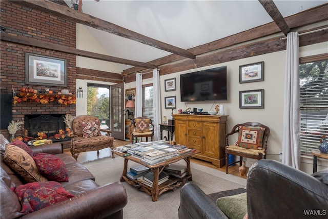 living room featuring beam ceiling, light hardwood / wood-style floors, and a fireplace