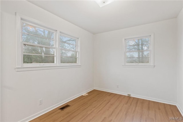 unfurnished room featuring a healthy amount of sunlight and light hardwood / wood-style floors