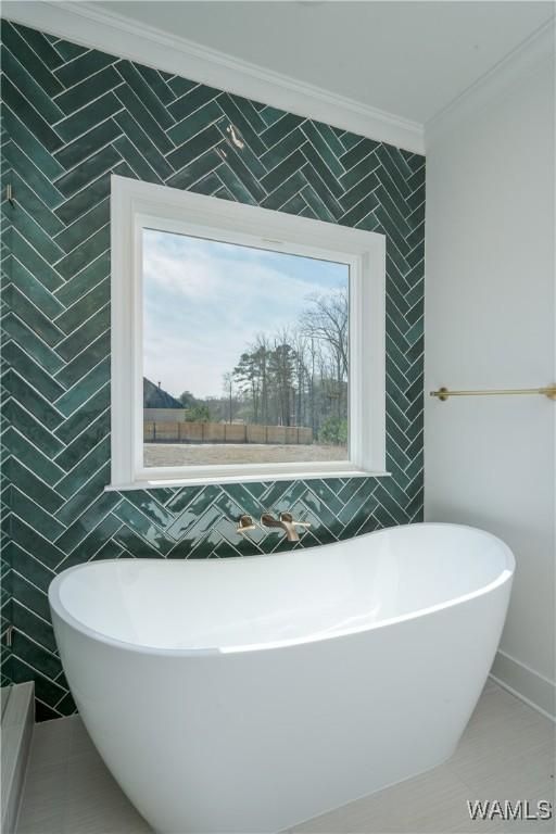 bathroom with tile walls, a bath, crown molding, and a wealth of natural light