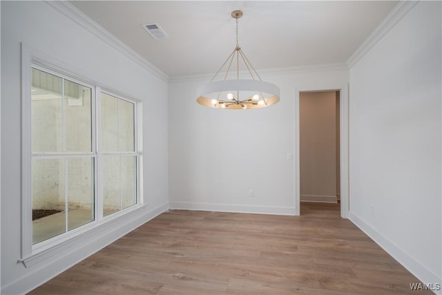 unfurnished dining area with crown molding, a chandelier, and hardwood / wood-style flooring